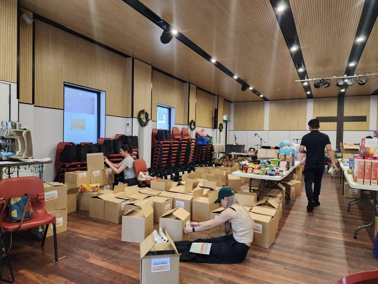 PACKED WITH LOVE: Packing food hampers at GracePoint church in Lidcombe.