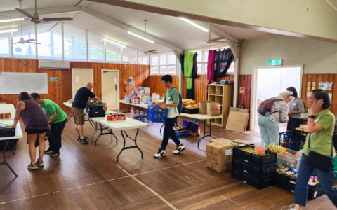 People setting up tables in a hall