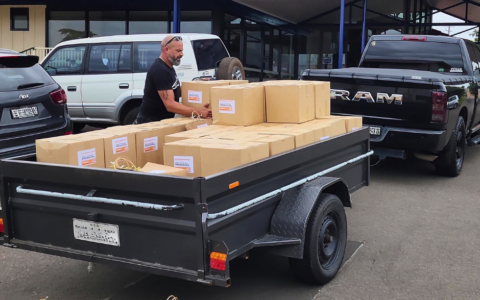 A man loading food hamper boxes into a trailer