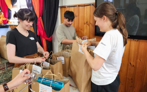 People Tying Ribbons for Gift bags