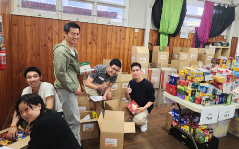 A group of people helping to pack food hamper boxes.